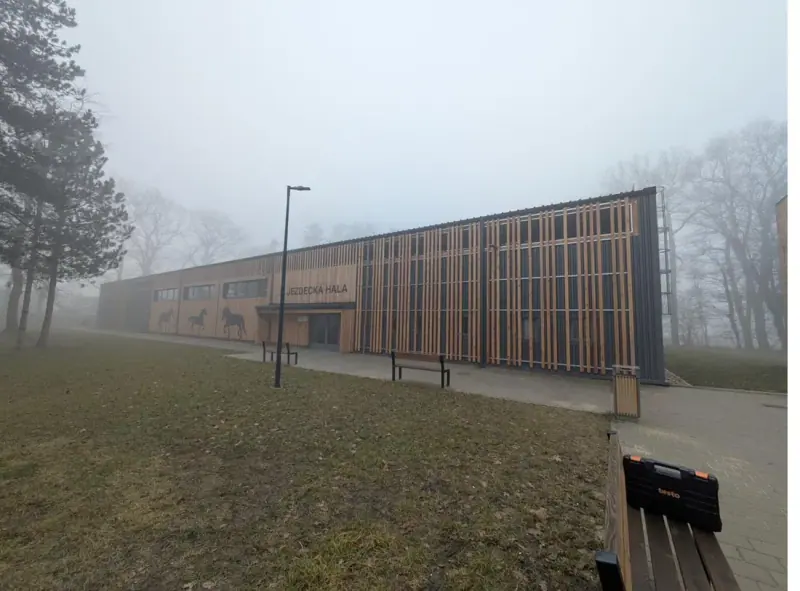 Budova střední školy v Kladrubech nad Labem s dřevěnou fasádou v mlze